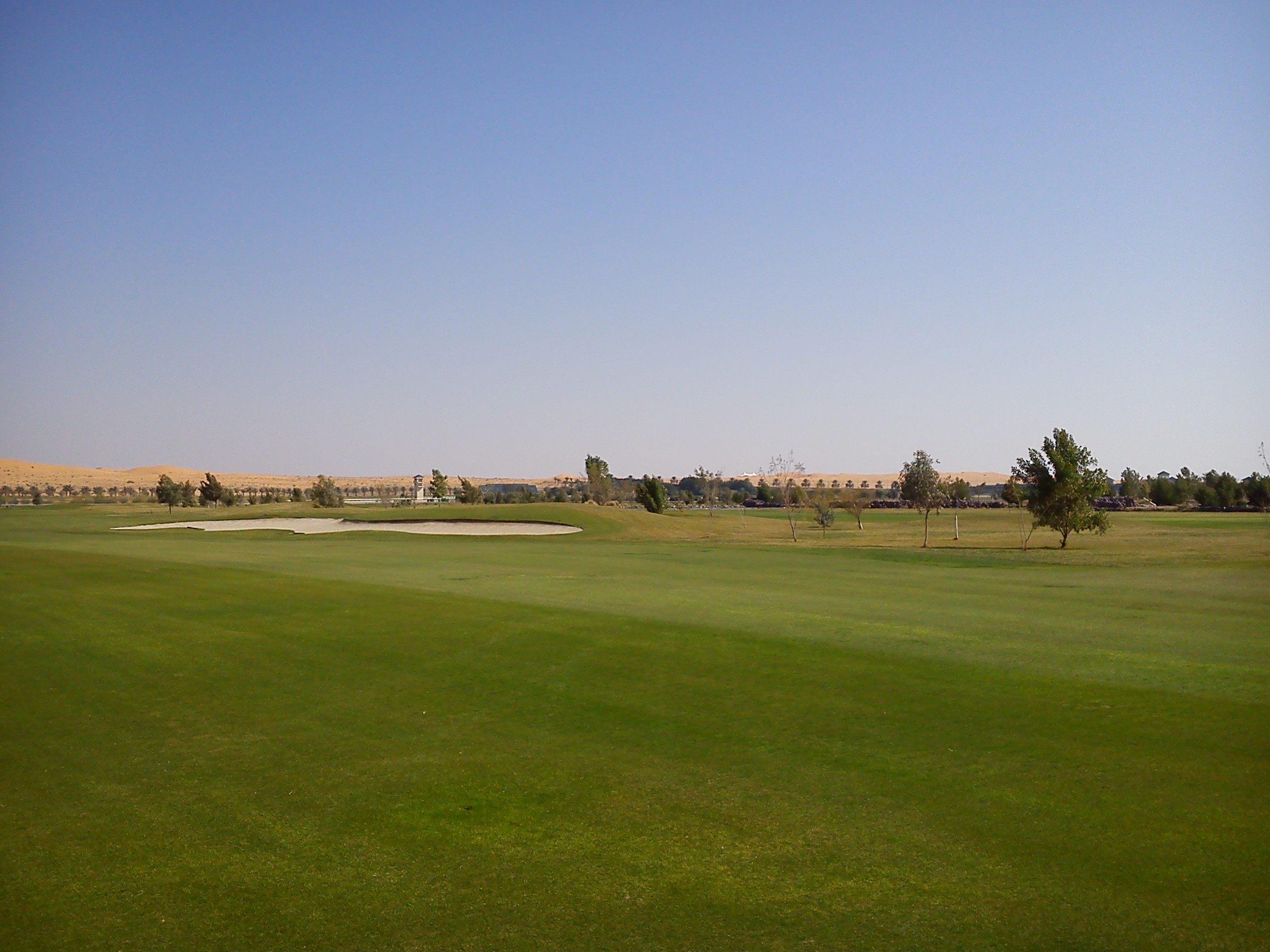 Well watered fairways contrast with the surrounding sand dunes at Nofa Golf Club